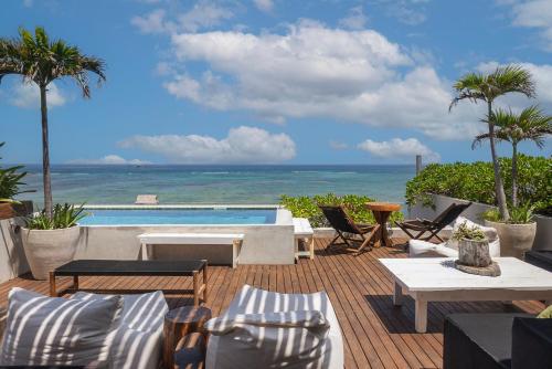 a patio with chairs and a swimming pool with the ocean at 3BR Beachfront with Private Rooftop at Tankah Bay in Tulum