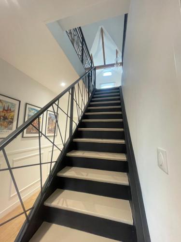 a staircase in a house with black and white stairs at Maison du Vignoble in Pfaffenheim