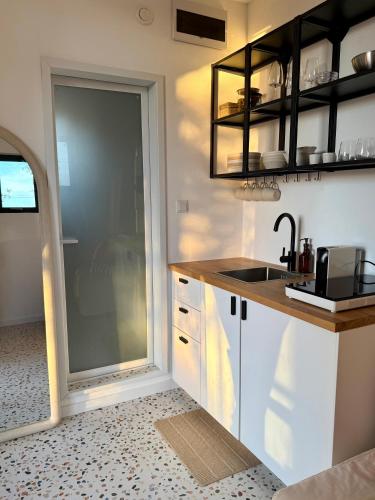 a kitchen with a sink and a counter with a window at Modern Tiny House with Big Comfort in Estômbar