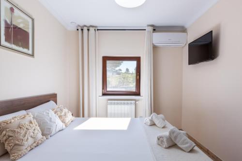 a bedroom with a white bed and a television at Casa Navajas in Jérica
