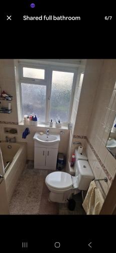 a bathroom with a toilet and a sink and a tub at Andrea house in Thornton Heath