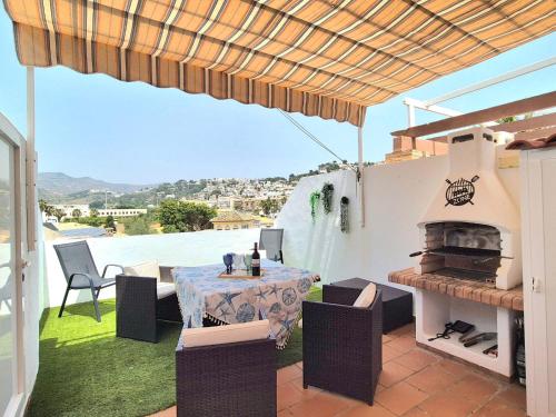 a patio with a table and chairs and a fireplace at Apartamento Alcazar in Almuñécar