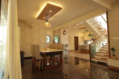 a dining room and kitchen with a table and chairs at Mon Reve Holidays in Kozhikode