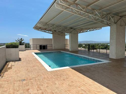 a swimming pool under a pergola with a swimming poolvisor at Modern Kingston Condo with Rooftop Pool and View in Kingston