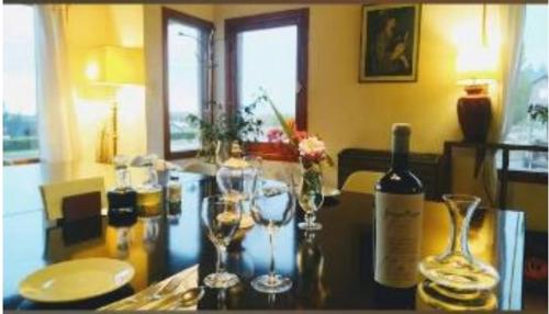 un tavolo con sopra dei bicchieri e una bottiglia di vino di Casa del Pino a El Calafate