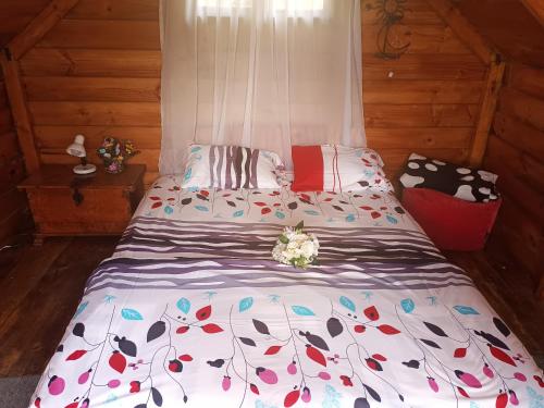 a bedroom with a bed with a floral comforter at Cabaña en el Campo in La Vega