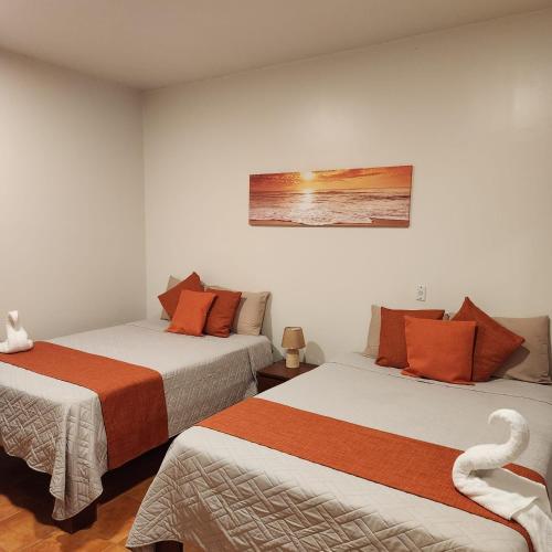a room with two beds and a swan on the wall at Hotel Hacienda Casa del Viento in Cuajiniquil