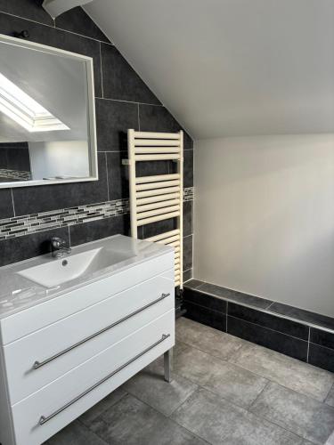 a bathroom with a sink and a mirror at Maison moderne avec jardin espace télétravail in Bobigny