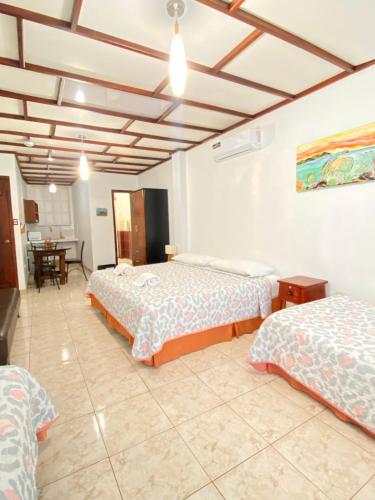 a hotel room with two beds and a dining room at Dreams Studios & Apartments in Puerto Ayora