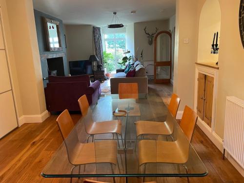 Una sala de estar con una mesa de cristal y sillas. en Spacious Garden Flat in Cheltenham, en Moffat