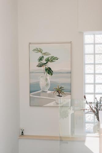 a painting of two plants in a vase on a shelf at Eressian Lodgings - Skala Eressos in Skala Eresou