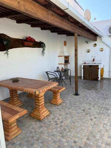 a patio with a wooden bench and a table at Cantinho Alentejano in Oriola