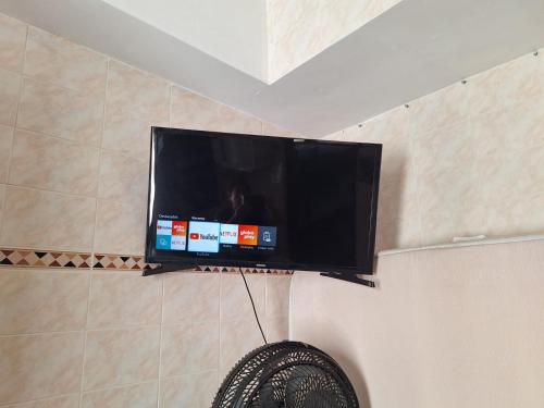 una TV a schermo piatto appesa a una parete di Kitnet maranduba a Ubatuba
