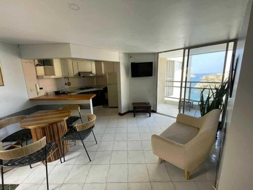 a kitchen and a living room with a table and chairs at Alojamientovacacional657 in Rodadero