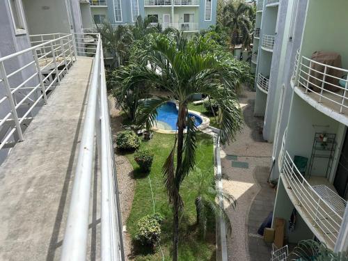 an apartment balcony with a swimming pool and palm trees at Private Condo with Pool in Tamarindo, Guanacaste in Tamarindo