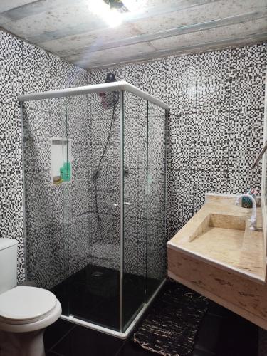 a bathroom with a shower and a toilet and a tub at Casa do aconchego k&P in Paraty