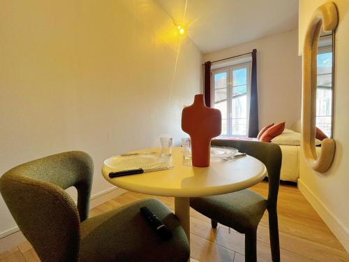une pièce avec une table, des chaises et un lit dans l'établissement Suite Olney, à Lyon