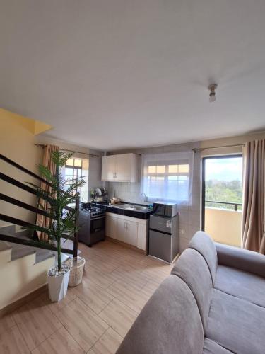 a living room with a couch and a kitchen at The Hideout, juja in Juja
