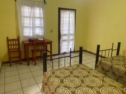 a bedroom with two beds and a table and chairs at Casa Bonita Centro in Oaxaca City
