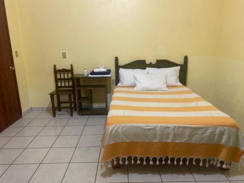 a bedroom with a bed with a desk and a chair at Casa Bonita Centro in Oaxaca City