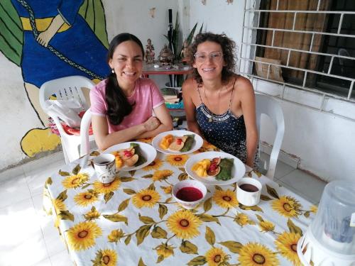 twee vrouwen aan een tafel met borden eten bij Samaringo hospedaje in Santa Marta