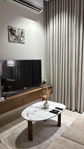 a living room with a television and a coffee table at شقة جديدة بغرفة وصالة in Al Kharj