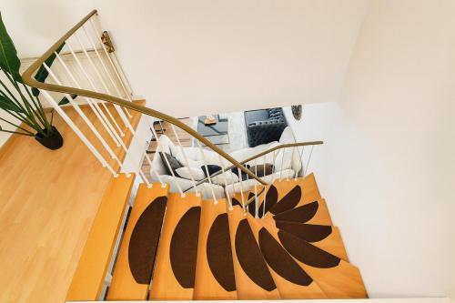 a living room with a spiral staircase with a couch at Ferienwohnung in Bad Vilbel mit Parkplatz nahe Messe, Frankfurt und Flughafen in Bad Vilbel