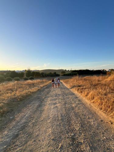 a group of three people walking down a dirt road at Casa do Capitão 