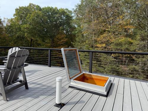 a mirror sitting on a deck next to a chair at Tuthill Tree House - Secluded Mountain Cabin with Roof Deck in Shohola