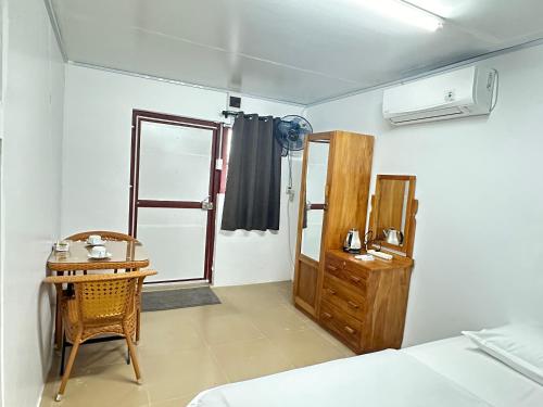 una camera con un letto, un tavolo e una finestra di Green sea apartment a Nadi