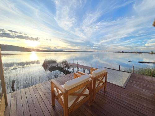 a deck with a bench and a view of a lake at Titicaca island lodge peru in Puno