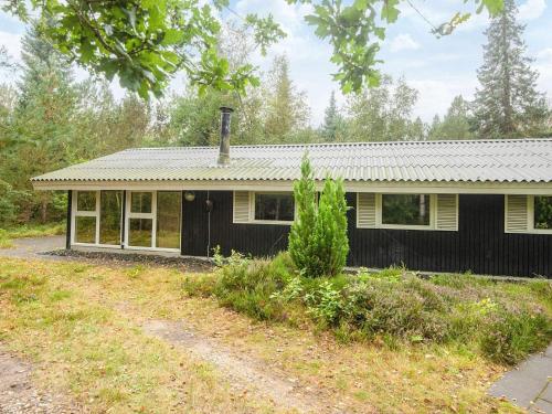 a black and white house in the middle of a field at 5 person holiday home in Herning-By Traum in Kølkær