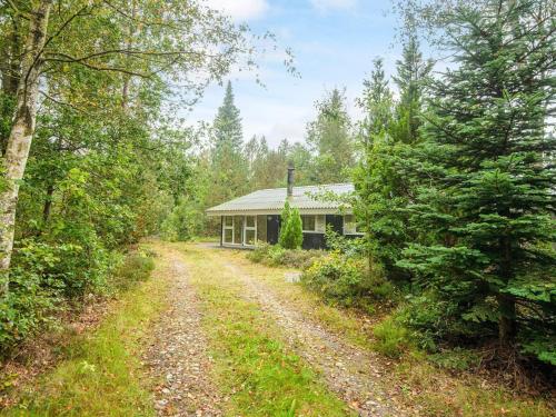 a dirt road leading to a house in the woods at 5 person holiday home in Herning-By Traum in Kølkær