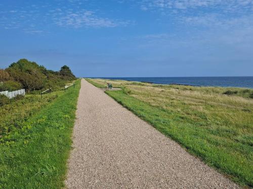a gravel path leading to the ocean on a beach at 5 person holiday home in Nakskov in Nakskov