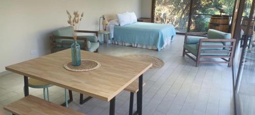 a living room with a table and a bed at Espacio Arenales in Paine
