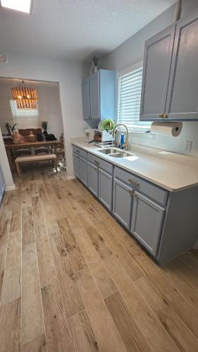 a kitchen with a sink and a wooden floor at Downtown Historic St Augustine! Quality, Comfort, Hospitality, FUN! putt putt in St. Augustine