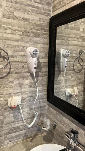 a bathroom mirror with a hair dryer on a wall at C4s4 RANCH OXAPAMPA in Oxapampa