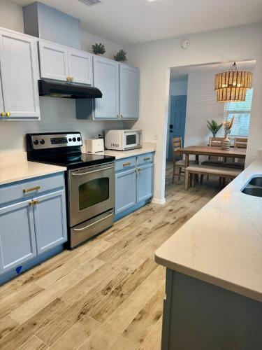 a kitchen with blue cabinets and a dining room with a table at Downtown Historic St Augustine! Quality, Comfort, Hospitality, FUN! putt putt in St. Augustine