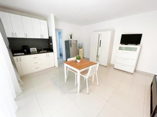 a white kitchen with a table and a refrigerator at SUITES SOL DEL SUN Caribbean HOTEL BEACH CLUB & SPA in Punta Cana