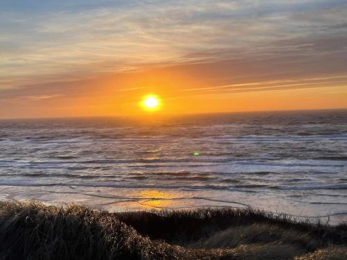 a sunset over the ocean with the sun setting at 6 person holiday home in Løkken in Løkken