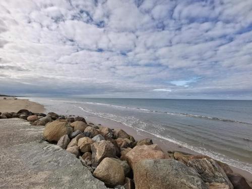 a group of rocks on the shore of a beach at 6 person holiday home in Løkken in Løkken