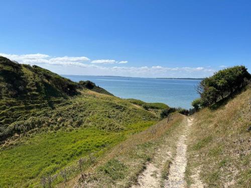 a dirt road on a hill next to the ocean at 6 person holiday home in Løgstør in Løgstør