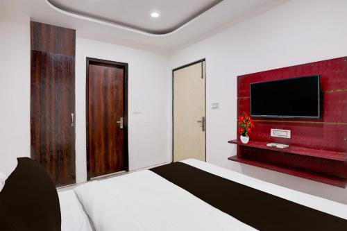 a bedroom with a bed and a flat screen tv at Super OYO 39654 hotel ACT in Ludhiana