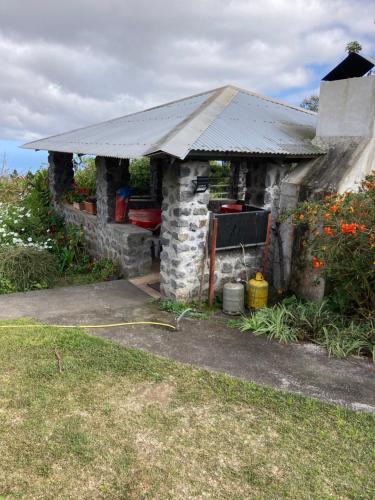 a stone house with a roof on top of it at Gîte LEUCALYPTUS in Saint-Paul