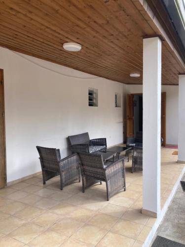 a patio with wicker chairs and a table on a porch at Gîte LEUCALYPTUS in Saint-Paul