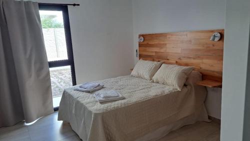 a bedroom with a bed with a wooden headboard at El Atardecer Apart in Federación