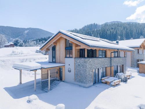 a house in the snow with snow on the roof at Almchalet Alpenglück in Sankt Lambrecht