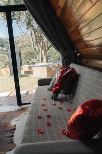 a bed in the back of a van with red rose petals at Chalé Manga Larga,Refúgio Romântico em Itaipava in Itaipava