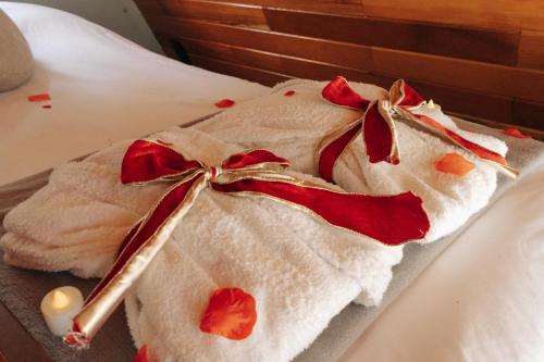 a white towel with a cigarette on a bed at Chalé Manga Larga,Refúgio Romântico em Itaipava in Itaipava
