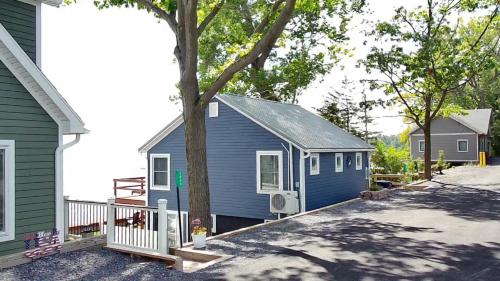 ein blaues Haus mit einem Baum davor in der Unterkunft Year-round Cozy Cottage Charm on Cayuga Lake in Romulus